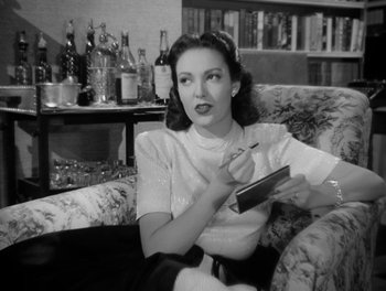 Movie still from “A Letter to Three Wives” (1949), directed by Joseph L. Mankiewicz – A black and white photo of a woman sitting on a couch; Medium shot, High angle