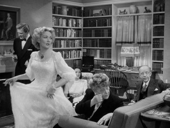 Movie still from “A Letter to Three Wives” (1949), directed by Joseph L. Mankiewicz – A woman in a white dress is dancing in front of a man; Medium shot, Over the shoulder angle