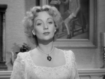 Movie still from “A Letter to Three Wives” (1949), directed by Joseph L. Mankiewicz – An old photo of a woman in a white dress; Close Up shot, Over the shoulder angle