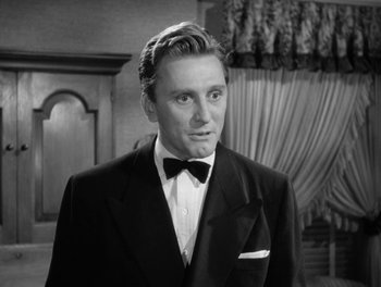Movie still from “A Letter to Three Wives” (1949), directed by Joseph L. Mankiewicz – A man wearing a suit and bow tie in front of a window; Close Up shot, Low angle