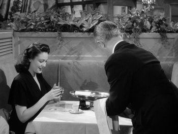 Movie still from “A Letter to Three Wives” (1949), directed by Joseph L. Mankiewicz – A man and a woman sitting at a table with wine glasses; Medium shot, High angle