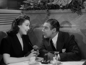 Movie still from “A Letter to Three Wives” (1949), directed by Joseph L. Mankiewicz – A man and a woman sitting at a table; Medium shot, High angle