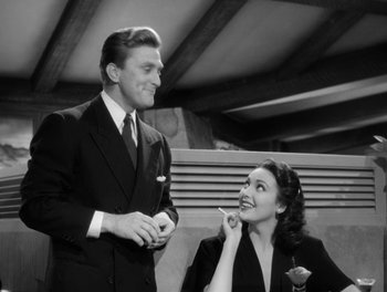 Movie still from “A Letter to Three Wives” (1949), directed by Joseph L. Mankiewicz – A man standing next to a woman while holding a pen; Medium shot, Low angle