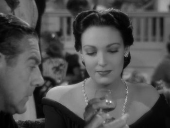 Movie still from “A Letter to Three Wives” (1949), directed by Joseph L. Mankiewicz – An old photo of a man and a woman holding a wine glass; Close Up shot, Over the shoulder angle