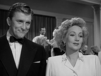 Movie still from “A Letter to Three Wives” (1949), directed by Joseph L. Mankiewicz – An old photo of a man and a woman posing for a picture; Medium shot, Low angle