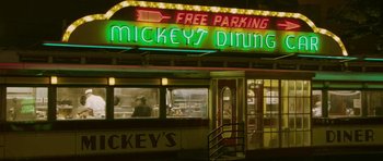 Movie still from “A Prairie Home Companion” (2006), directed by Robert Altman – A neon sign for mickey's diner at night time; Extreme Wide shot, High angle
