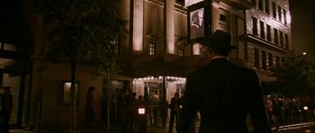 Movie still from “A Prairie Home Companion” (2006), directed by Robert Altman – A group of people standing in front of a building at night; Wide shot, Low angle