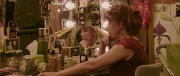 Movie still from “A Prairie Home Companion” (2006), directed by Robert Altman – A woman sitting in front of a mirror in a dressing room; Close Up shot, High angle