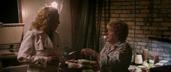 Movie still from “A Prairie Home Companion” (2006), directed by Robert Altman – Two women standing in front of a tray of food; Medium shot, Over the shoulder angle