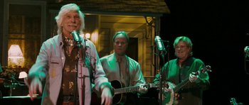 Movie still from “A Prairie Home Companion” (2006), directed by Robert Altman – A group of people that are standing in front of a microphone; Medium shot, Low angle
