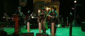 Movie still from “A Prairie Home Companion” (2006), directed by Robert Altman – A group of men playing instruments on a stage; Wide shot, High angle