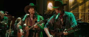 Movie still from “A Prairie Home Companion” (2006), directed by Robert Altman – A couple of men in cowboy hats playing guitars; Medium shot, Over the shoulder angle