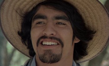 Movie still from “Alambrista!” (1977), directed by Robert M. Young – A person wearing a straw hat; Close Up shot, Low angle