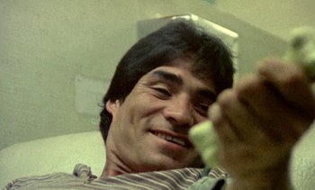 Movie still from “Alambrista!” (1977), directed by Robert M. Young – A person holding a cell phone; Extreme Close Up shot, Low angle