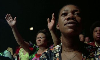 Movie still from “Alambrista!” (1977), directed by Robert M. Young – A group of people standing in front of each other with their hands raised; Close Up shot, Low angle