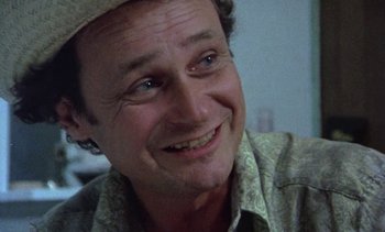Movie still from “Alambrista!” (1977), directed by Robert M. Young – A person wearing a hat and smiling; Close Up shot, Low angle
