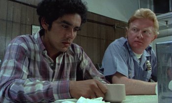 Movie still from “Alambrista!” (1977), directed by Robert M. Young – A man sitting at a table with a cup of coffee; Close Up shot, Low angle