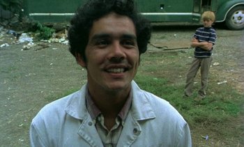 Movie still from “Alambrista!” (1977), directed by Robert M. Young – A man in a white jacket smiling for the camera; Close Up shot, Low angle