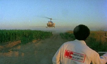 Movie still from “Alambrista!” (1977), directed by Robert M. Young – A man standing in the dirt looking at a helicopter; Extreme Wide shot, High angle