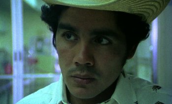 Movie still from “Alambrista!” (1977), directed by Robert M. Young – A person wearing a straw hat; Close Up shot, Low angle