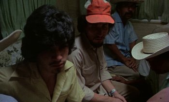 Movie still from “Alambrista!” (1977), directed by Robert M. Young – A group of men sitting next to each other on a couch; Close Up shot, High angle