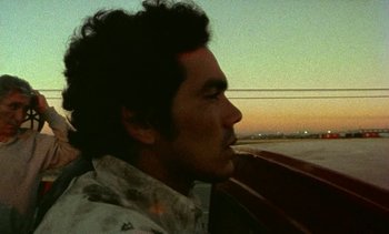 Movie still from “Alambrista!” (1977), directed by Robert M. Young – A person sitting in a boat; Close Up shot, Low angle
