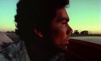 Movie still from “Alambrista!” (1977), directed by Robert M. Young – A person in a boat on a body of water; Extreme Close Up shot, Low angle