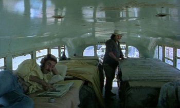 Movie still from “Alambrista!” (1977), directed by Robert M. Young – A man sitting on a bed next to another man; Wide shot, High angle