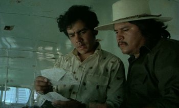 Movie still from “Alambrista!” (1977), directed by Robert M. Young – Two men looking at a piece of paper together; Close Up shot, High angle