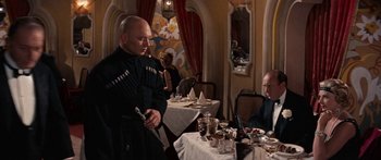 Movie still from “Anastasia” (1956), directed by Anatole Litvak – A man standing in front of a dining room table; Medium shot, Over the shoulder angle