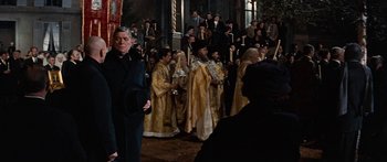 Movie still from “Anastasia” (1956), directed by Anatole Litvak – A group of men in robes and hats in front of a crowd; Medium shot, Over the shoulder angle