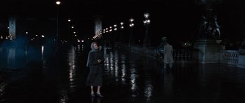 Movie still from “Anastasia” (1956), directed by Anatole Litvak – A person standing in the rain on a bridge at night; Wide shot, High angle
