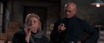 Movie still from “Anastasia” (1956), directed by Anatole Litvak – A man and a woman are smoking a cigarette together; Medium shot, Low angle