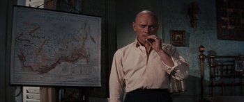 Movie still from “Anastasia” (1956), directed by Anatole Litvak – A bald man standing in front of a map; Medium shot, Low angle