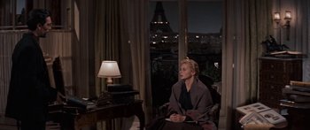Movie still from “Anastasia” (1956), directed by Anatole Litvak – A woman sitting in a chair in front of a window; Wide shot, Over the shoulder angle