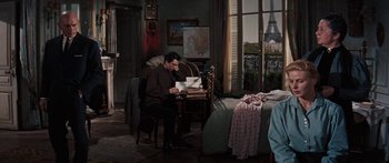 Movie still from “Anastasia” (1956), directed by Anatole Litvak – A man sitting at a desk in front of an open window; Medium shot, High angle