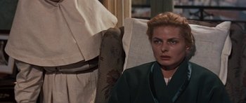 Movie still from “Anastasia” (1956), directed by Anatole Litvak – A woman sitting on a chair in front of a wall; Close Up shot, Over the shoulder angle