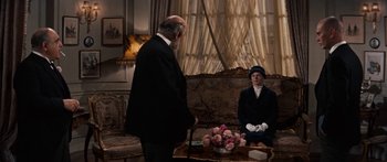 Movie still from “Anastasia” (1956), directed by Anatole Litvak – A man and a woman sitting in a living room next to each other; Medium shot, Over the shoulder angle