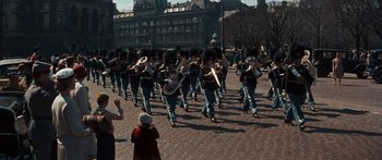 Movie still from “Anastasia” (1956), directed by Anatole Litvak – A group of people marching down a street with instruments; Extreme Wide shot, High angle