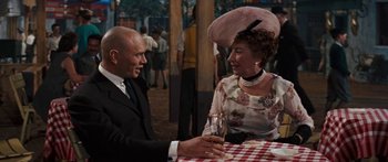 Movie still from “Anastasia” (1956), directed by Anatole Litvak – A man and a woman sitting at a table with a glass of wine in front of them; Medium shot, Over the shoulder angle