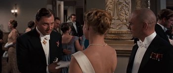 Movie still from “Anastasia” (1956), directed by Anatole Litvak – A man and a woman standing next to each other in front of a group of people; Medium shot, Over the shoulder angle