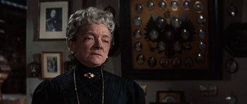 Movie still from “Anastasia” (1956), directed by Anatole Litvak – An older woman in a black dress and a necklace; Close Up shot, Low angle