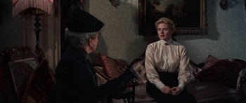 Movie still from “Anastasia” (1956), directed by Anatole Litvak – A woman sitting on a chair next to an older man; Medium shot, Over the shoulder angle