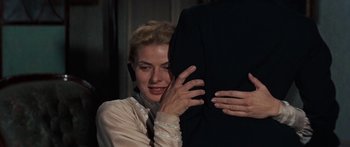 Movie still from “Anastasia” (1956), directed by Anatole Litvak – A woman in a white dress and a man in a black suit hug; Close Up shot, Over the shoulder angle