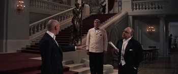 Movie still from “Anastasia” (1956), directed by Anatole Litvak – Three men in suits are standing in front of a staircase; Wide shot, Over the shoulder angle