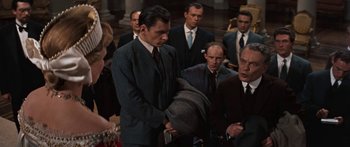 Movie still from “Anastasia” (1956), directed by Anatole Litvak – A group of men and women in suits and hats; Medium shot, Over the shoulder angle