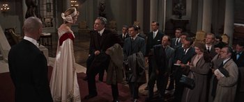 Movie still from “Anastasia” (1956), directed by Anatole Litvak – A group of men in suits and ties standing in front of a woman; Wide shot, Over the shoulder angle
