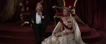 Movie still from “Anastasia” (1956), directed by Anatole Litvak – A man and a woman sitting on a stage; Medium shot, Low angle