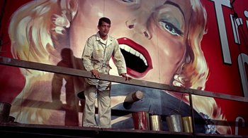 Movie still from “Artists and Models” (1955), directed by Frank Tashlin – A man standing in front of a painting of a woman; Medium shot, Low angle