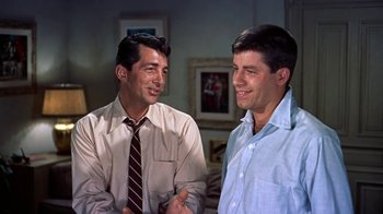 Movie still from “Artists and Models” (1955), directed by Frank Tashlin – Two men are talking and smiling for the camera; Medium shot, Over the shoulder angle